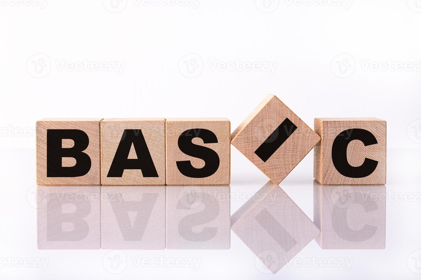 BASIC word, text written on wooden cubes on a white background with reflection. photo