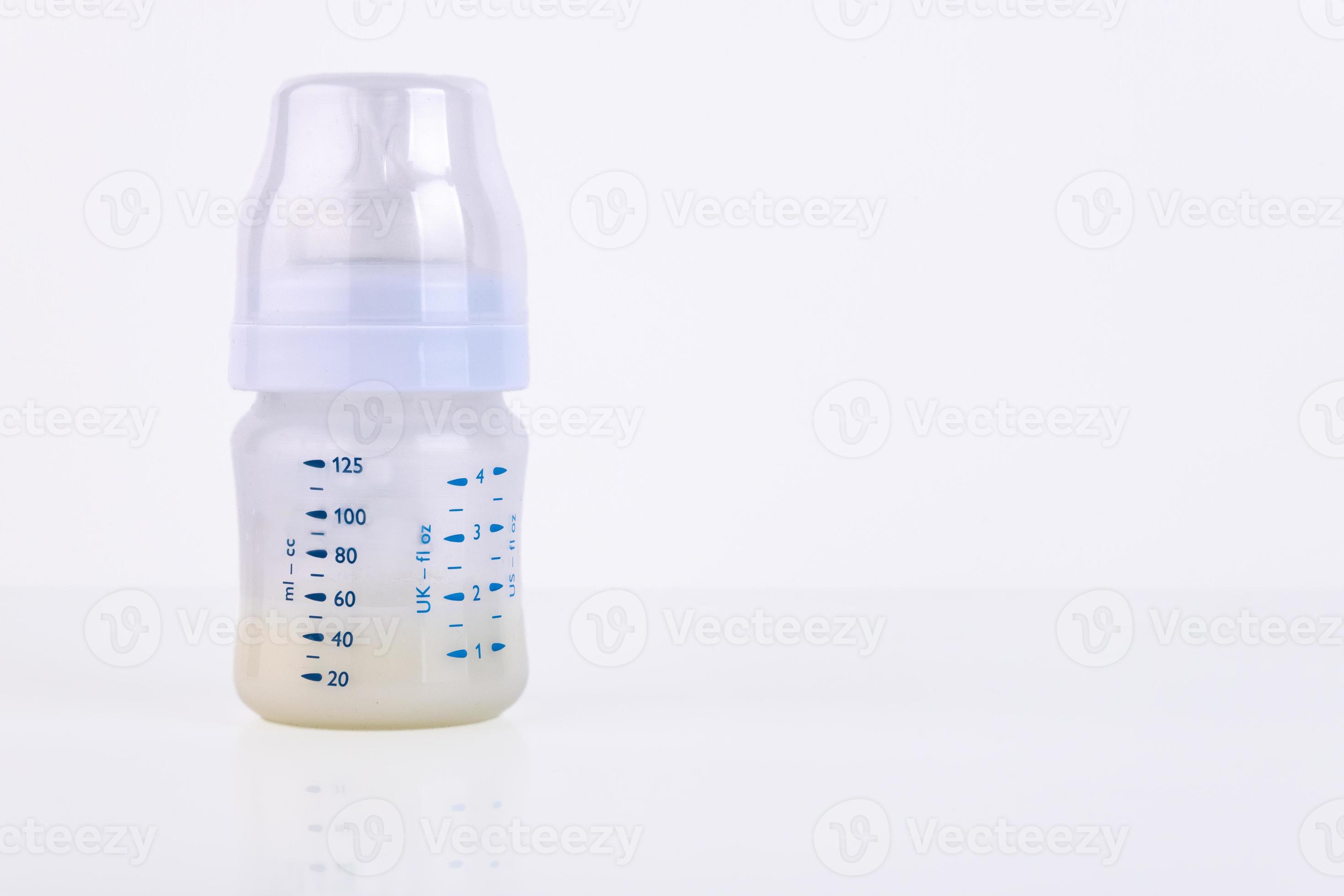 Baby bottle with pacifier and milk for feeding milk on a light
