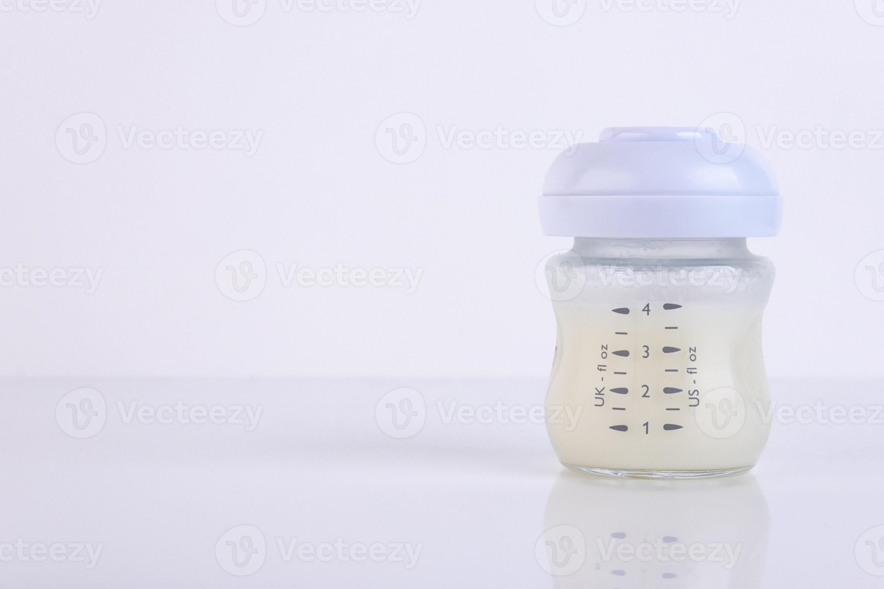 Baby bottle with pacifier and milk for feeding milk on a light