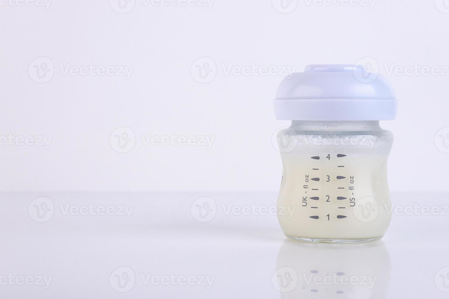 Baby bottle with pacifier and milk for feeding milk on a light background. Copy space. photo