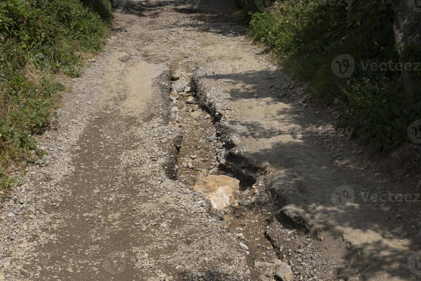 Bad road, pothole on the asphalt road in the highlands after the rainy season. photo