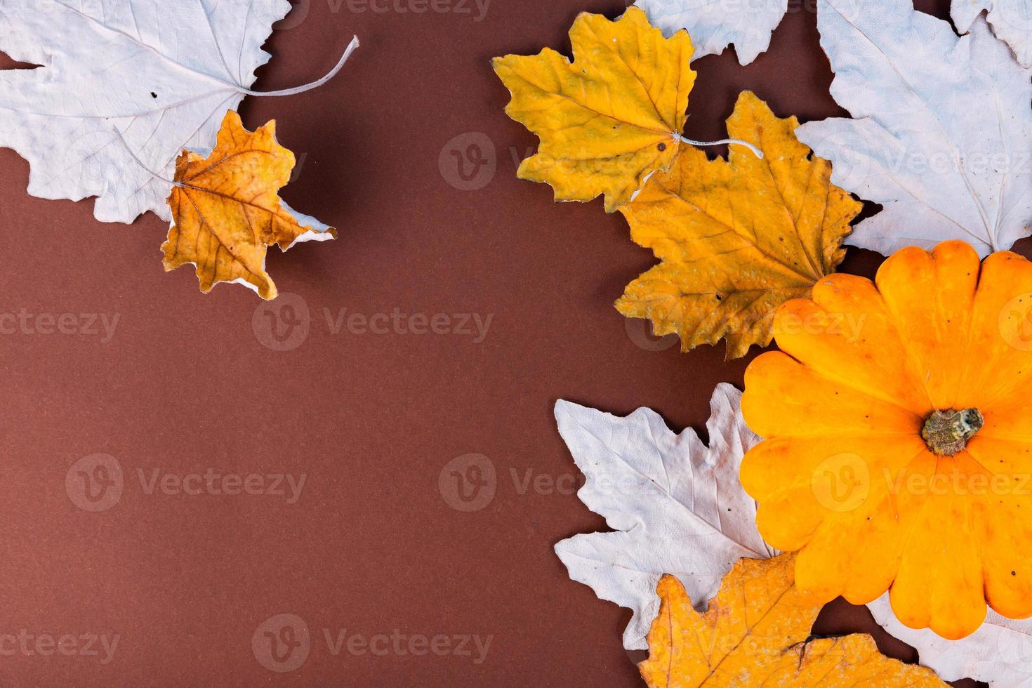 Autumn, maple, dry, yellow leaves, pumpkin, on an old wooden background with copy space. photo