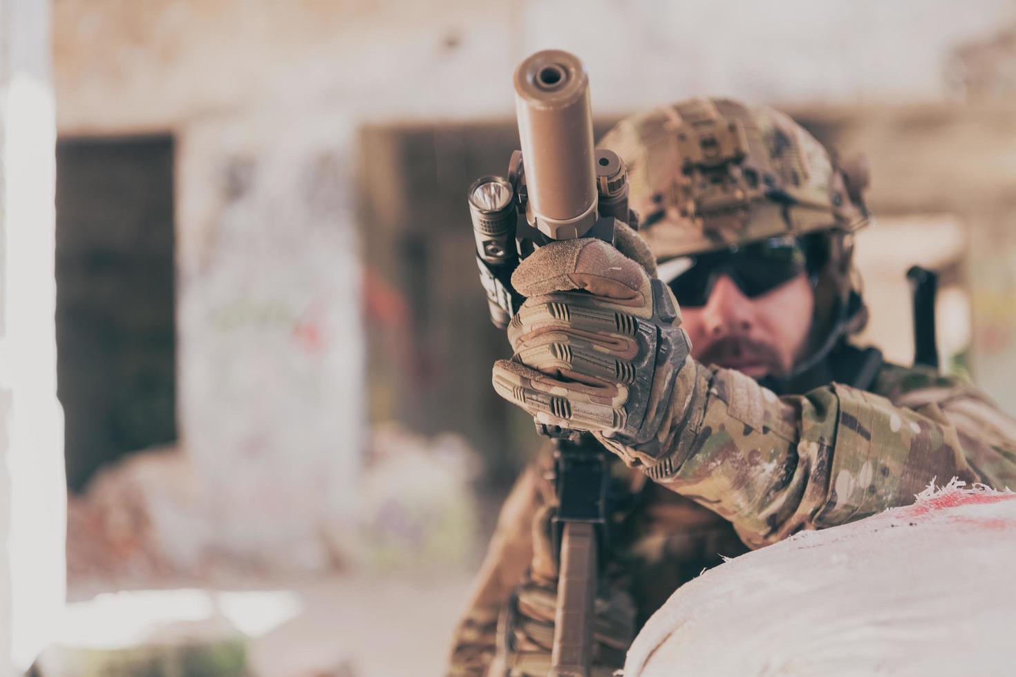 A bearded soldier in uniform of special forces in a dangerous military action in a dangerous enemy area. Selective focus photo