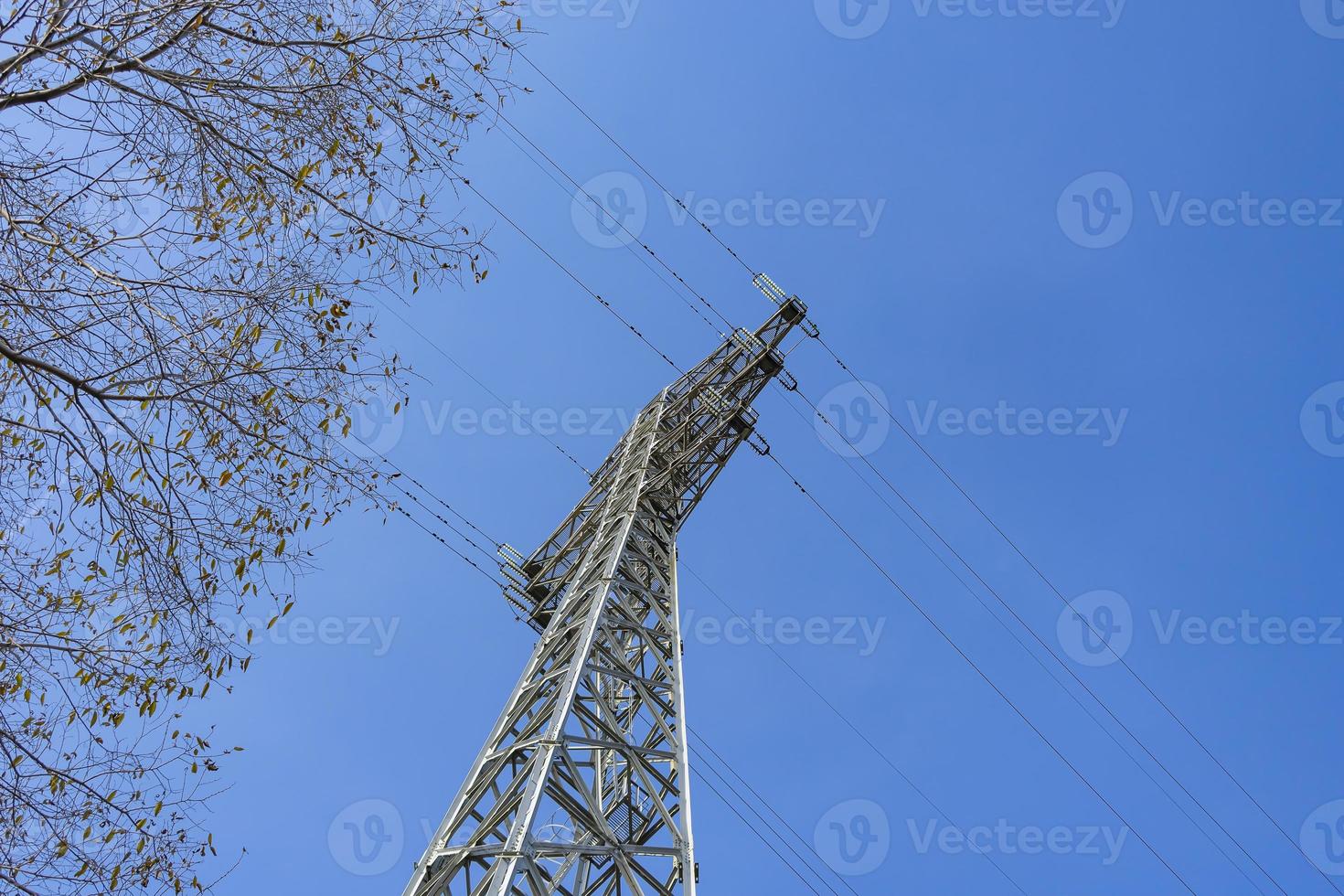 Bottom view of a power transmission tower against the sky photo