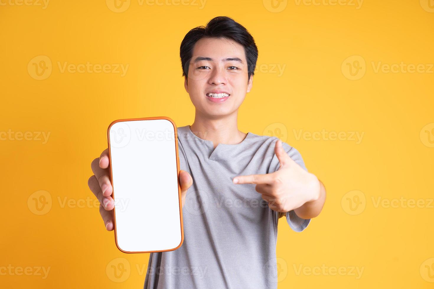 Asian young man posing on a yellow background photo