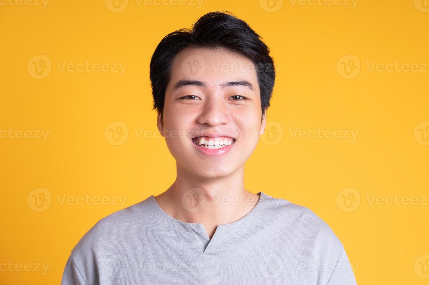 Asian young man posing on a yellow background photo