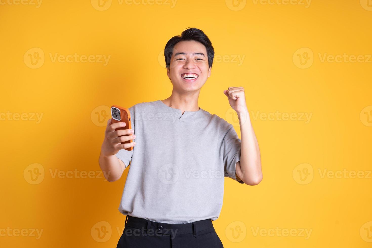 Asian young man posing on a yellow background photo
