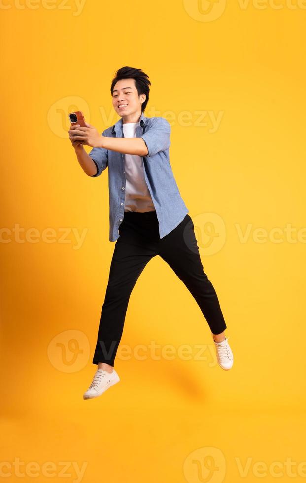 full body image of asian man posing on yellow background photo