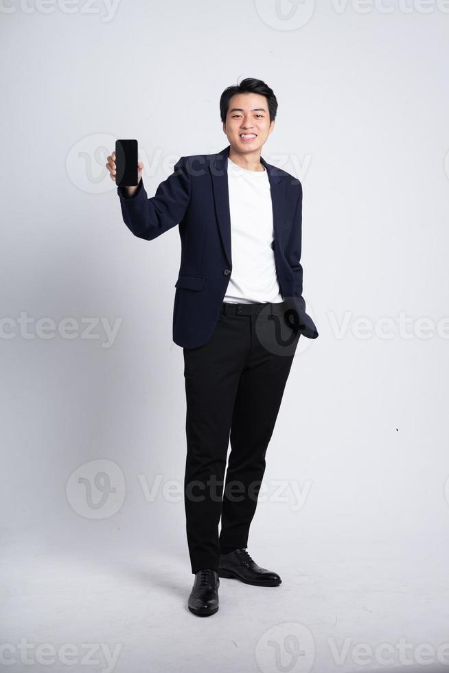 Young business man wearing a suit posing on a white background photo