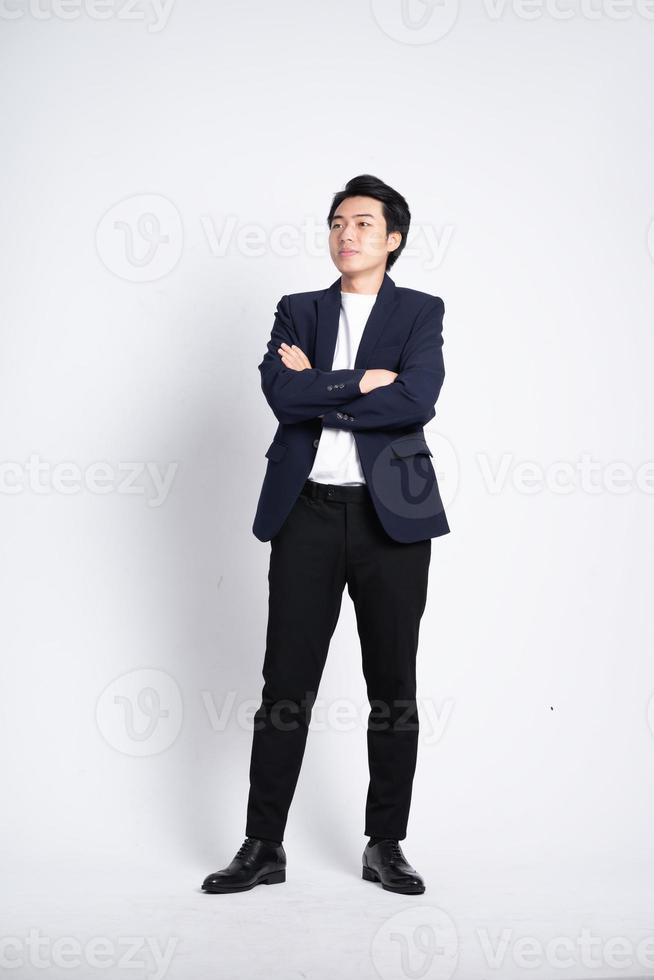 Young business man wearing a suit posing on a white background photo