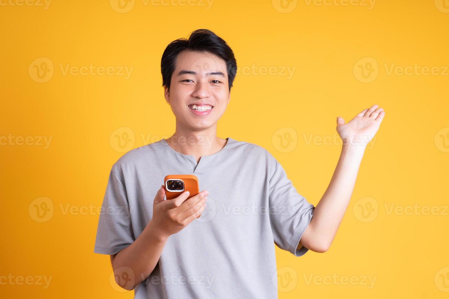 Asian young man posing on a yellow background photo