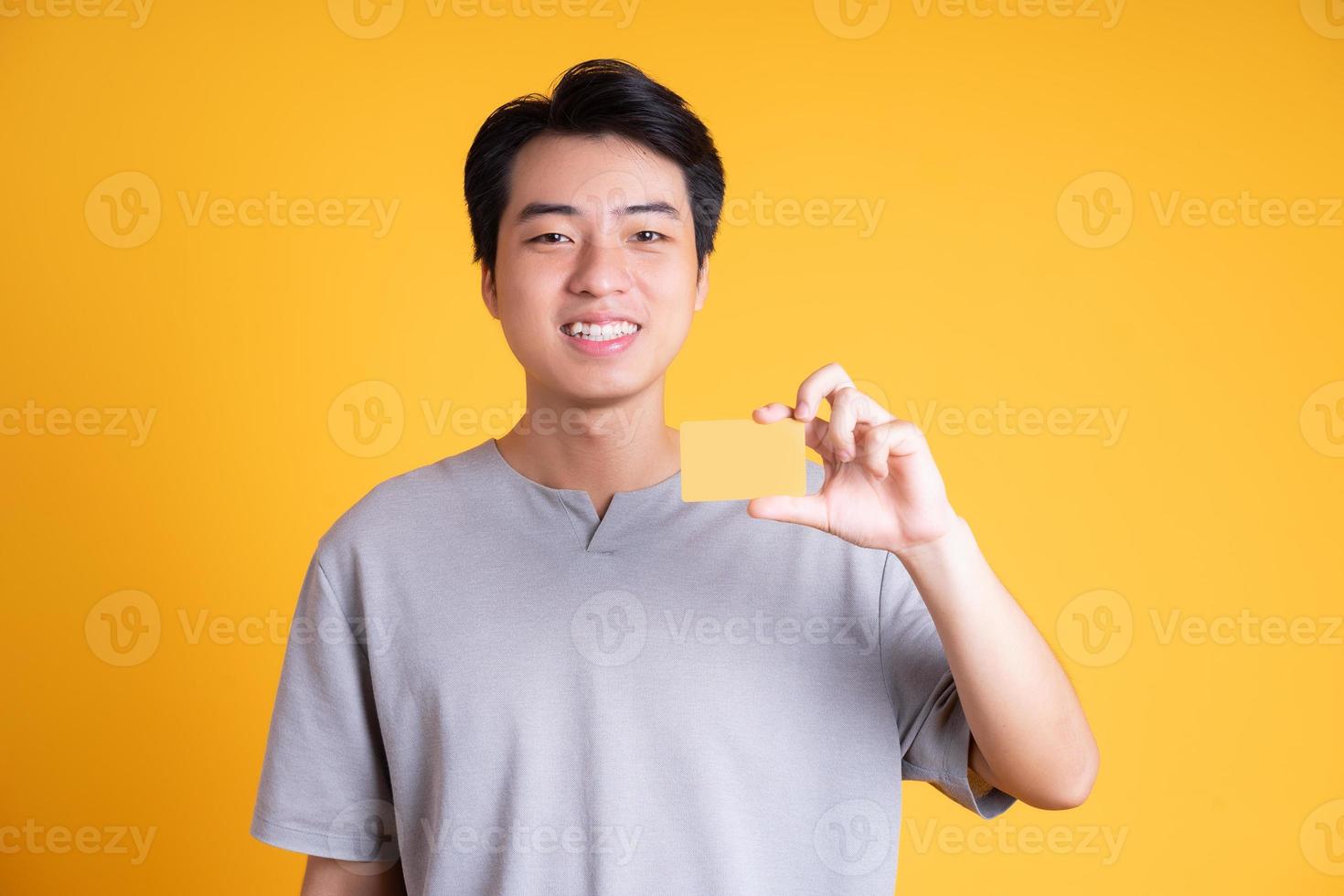 Asian young man posing on a yellow background photo