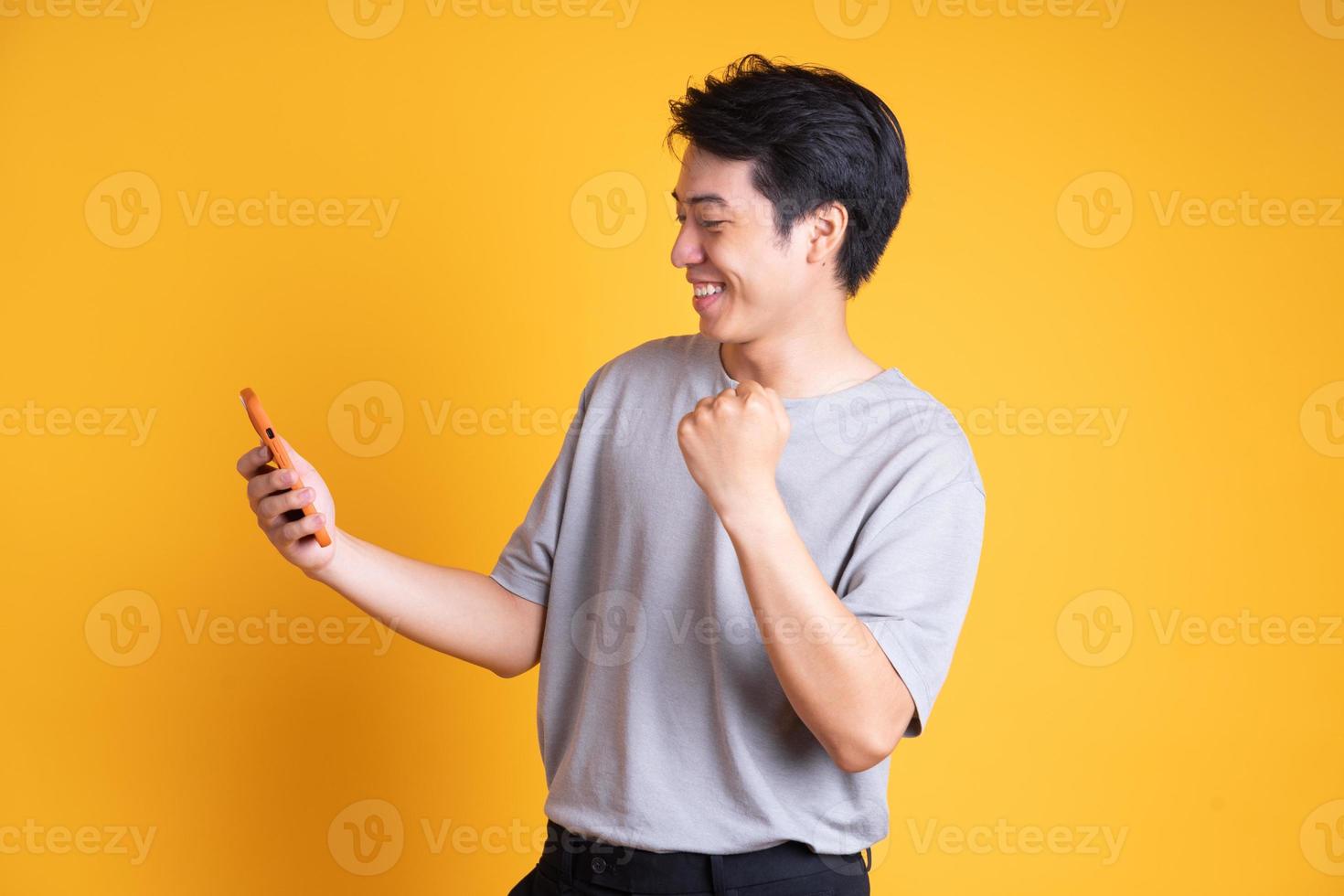 Asian young man posing on a yellow background photo