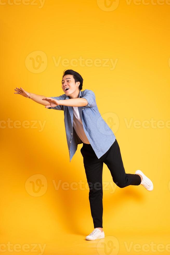 full body image of asian man posing on yellow background photo
