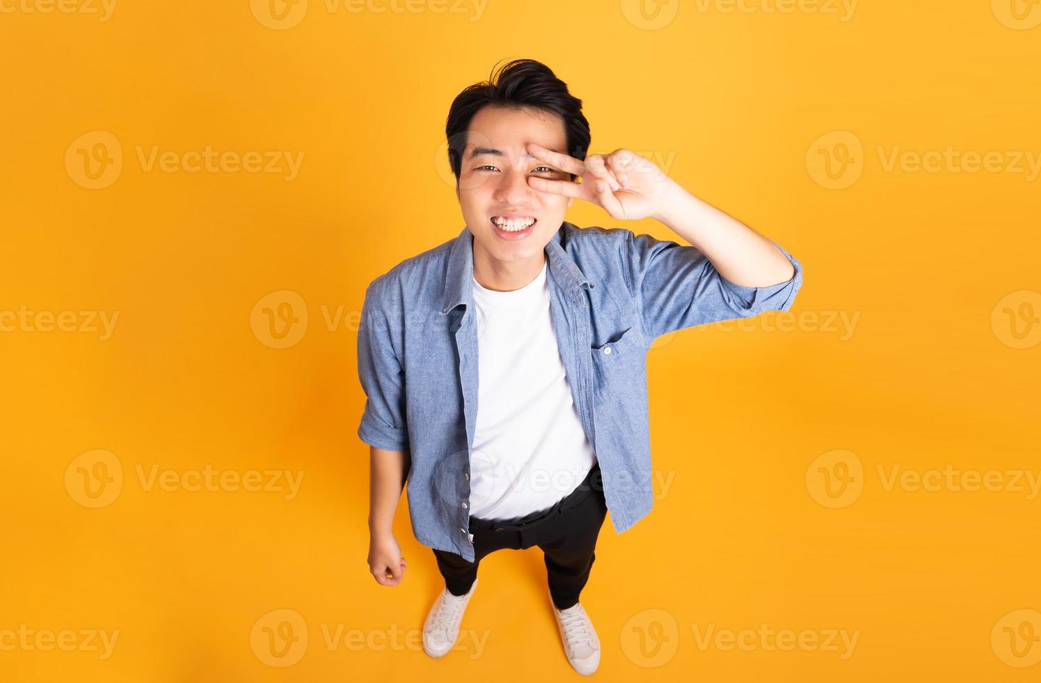 imagen de un hombre asiático posando sobre un fondo amarillo foto