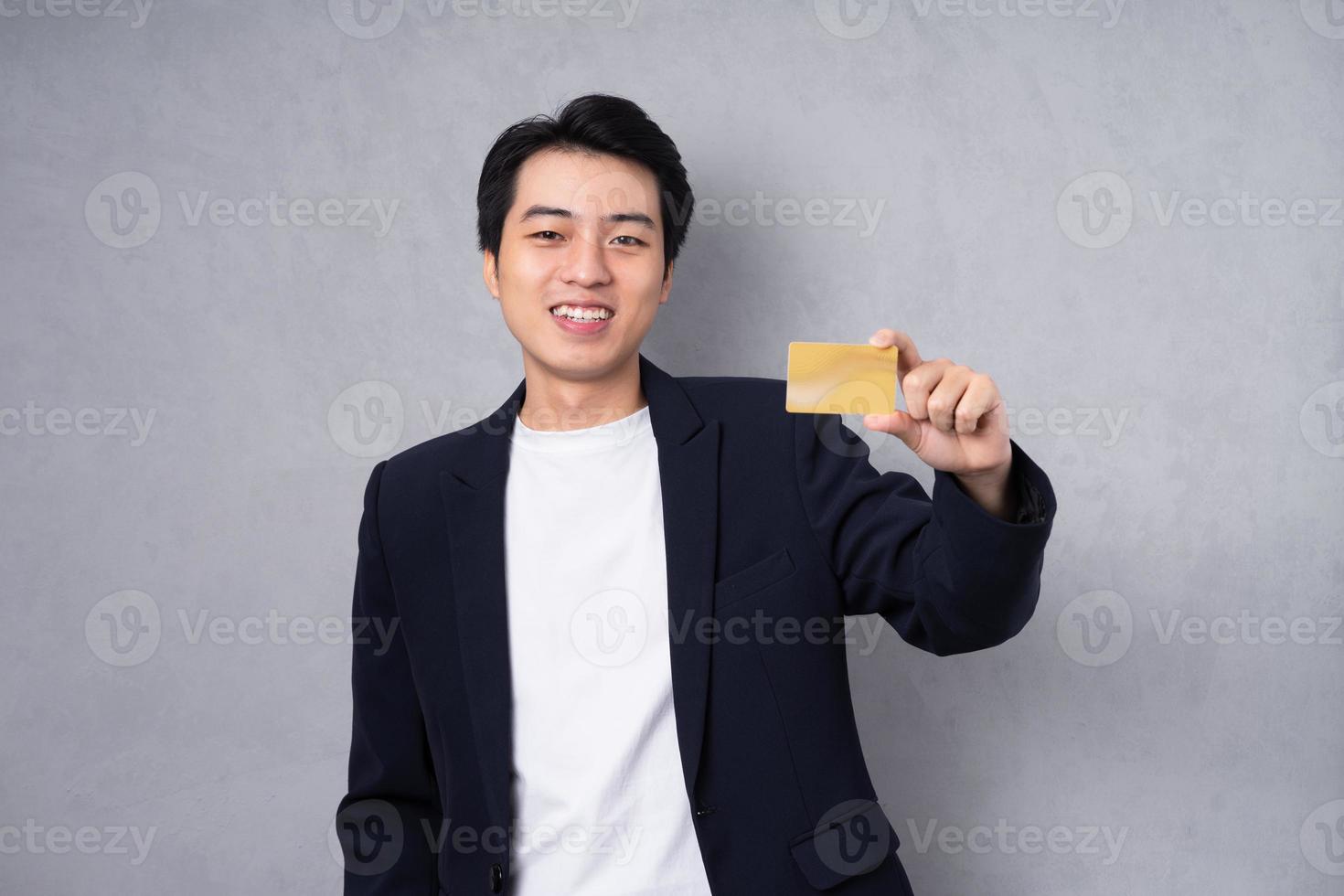 Young business man wearing a suit posing on a grey background photo