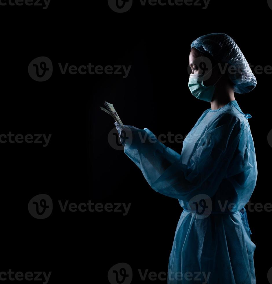 Surgeon Doctor receive money and it looks like corruption crime over black background. Doctor has not ethic responsibility and illegal. Black background underexposure for shadow environment copy space photo