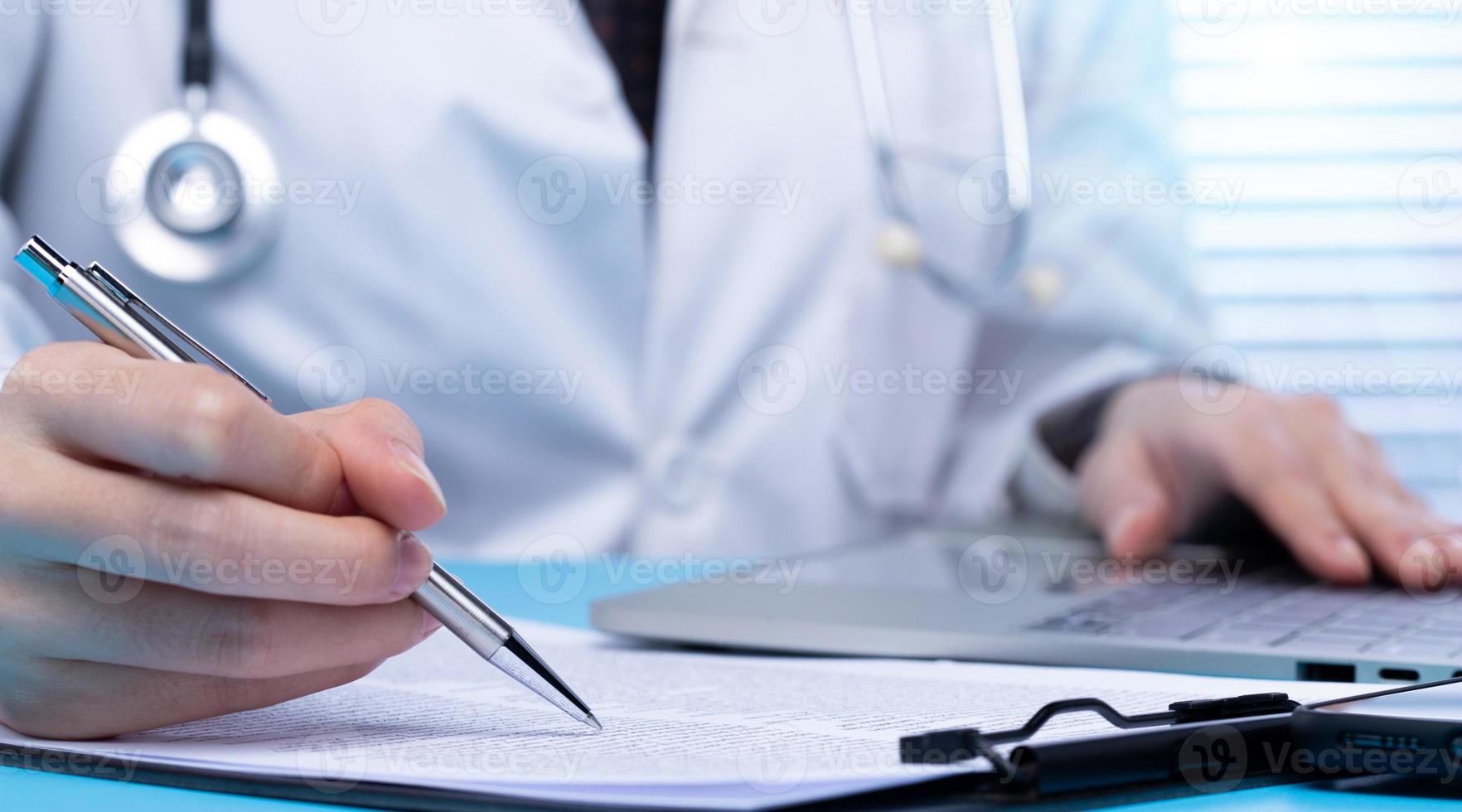 Professional Doctor sign Health care medical document of patient medicine in hospital office. Doctor wear lab coat uniform read patient chart on desk for insurance person and note pen, copy space photo