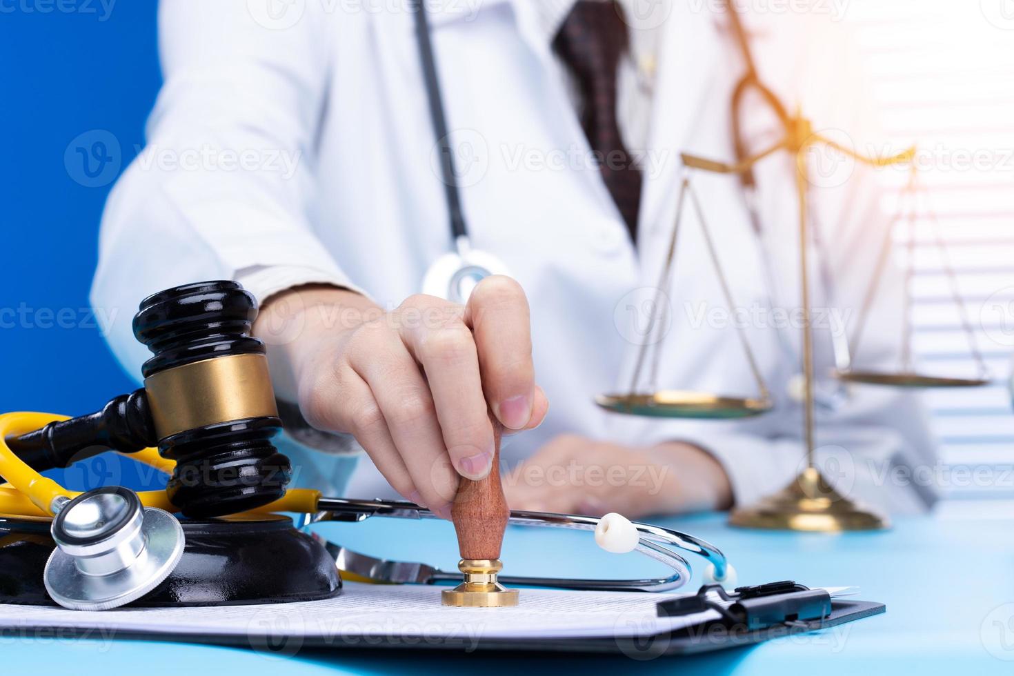 Doctor stamp approval with authority to patient to death. Law legal protect medical doctor from criminal court judgement. Concept with stethoscope balance scale mullet hammer, copy space photo