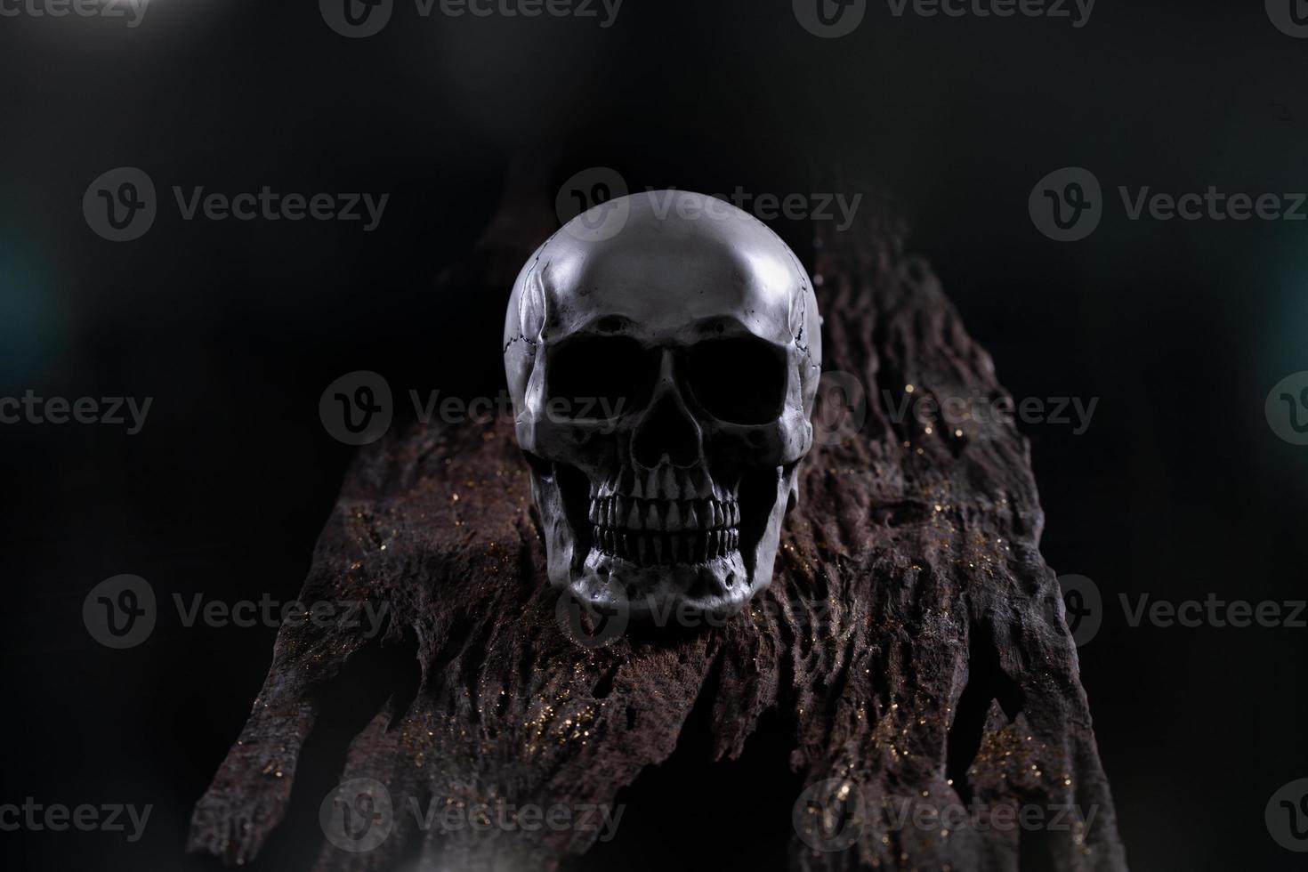 Halloween human skull on an old wooden table over black background. Shape of skull bone for Death head on halloween festival which show horror evil tooth fear and scary with fog smoke, copy space photo