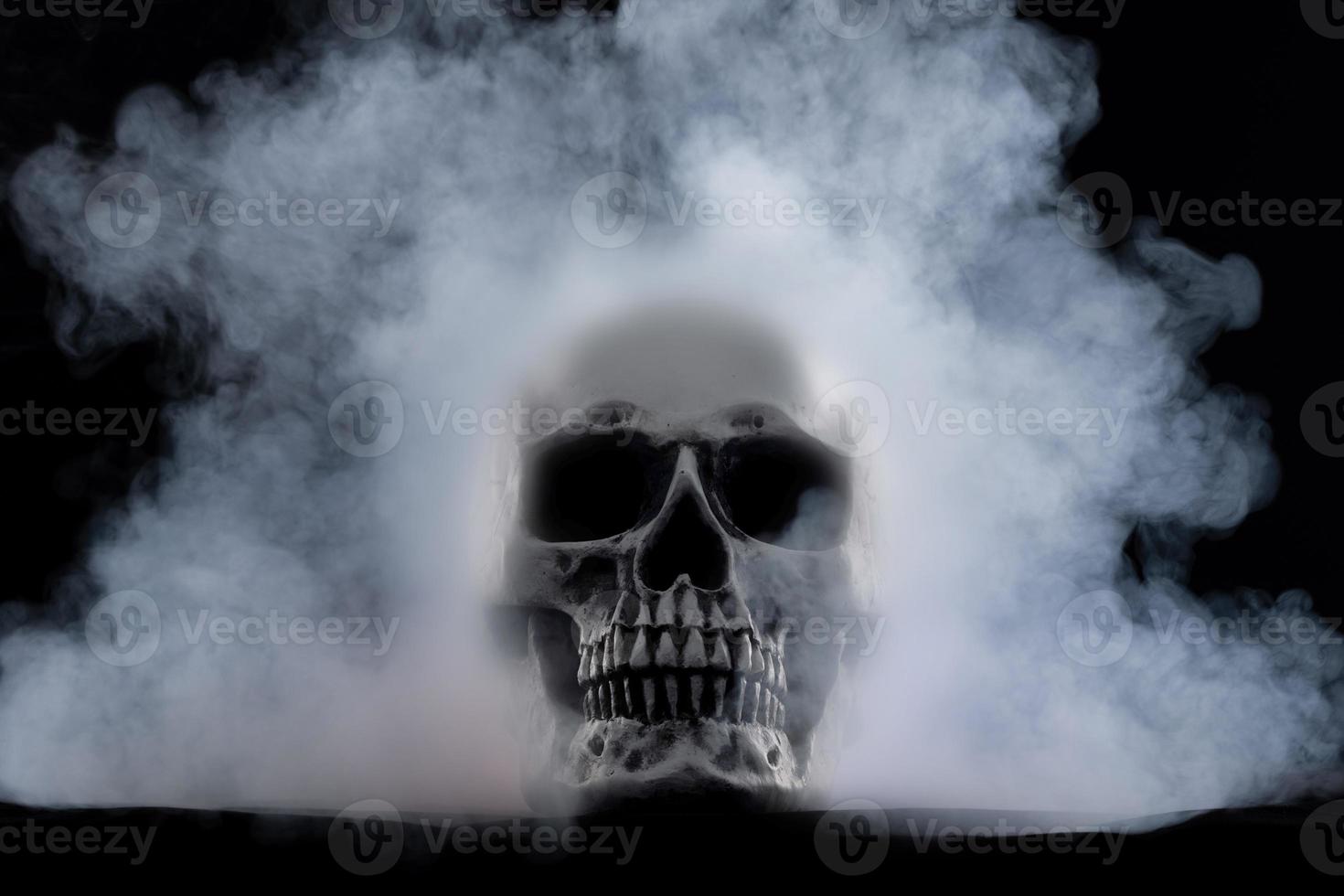 Halloween human skull on an old wooden table over black background. Shape of skull bone for Death head on halloween festival which show horror evil tooth fear and scary with fog smoke, copy space photo