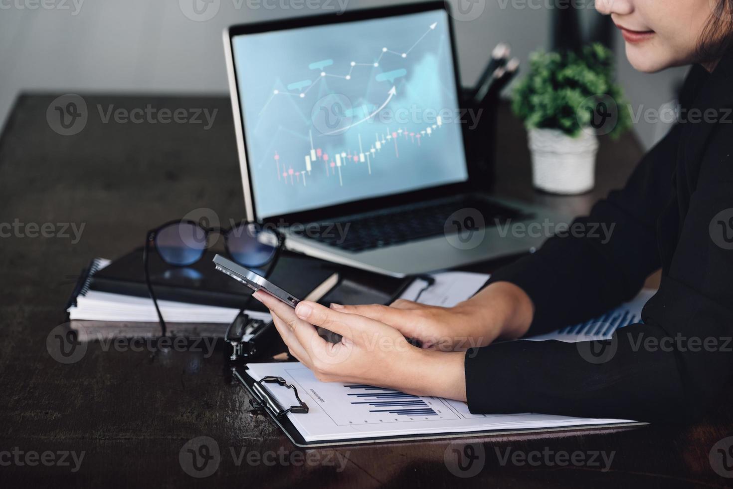 Concept of stock market analysis, financial statements, investments, Asian women entrepreneurs are using mobile phones and computers to manage funds efficiently by working through internet technology. photo