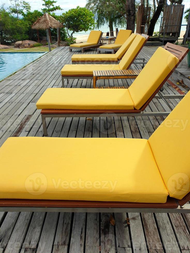 Sun or beach beds beside the pool which nearby a beach with background of sea in long sight. photo