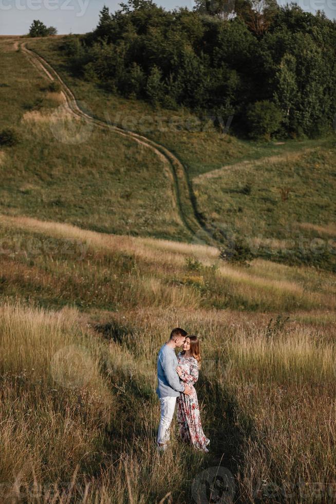 loving couple hold hands and hugging outside in the field at summer. Concept of love and family. copy space. selective focus photo