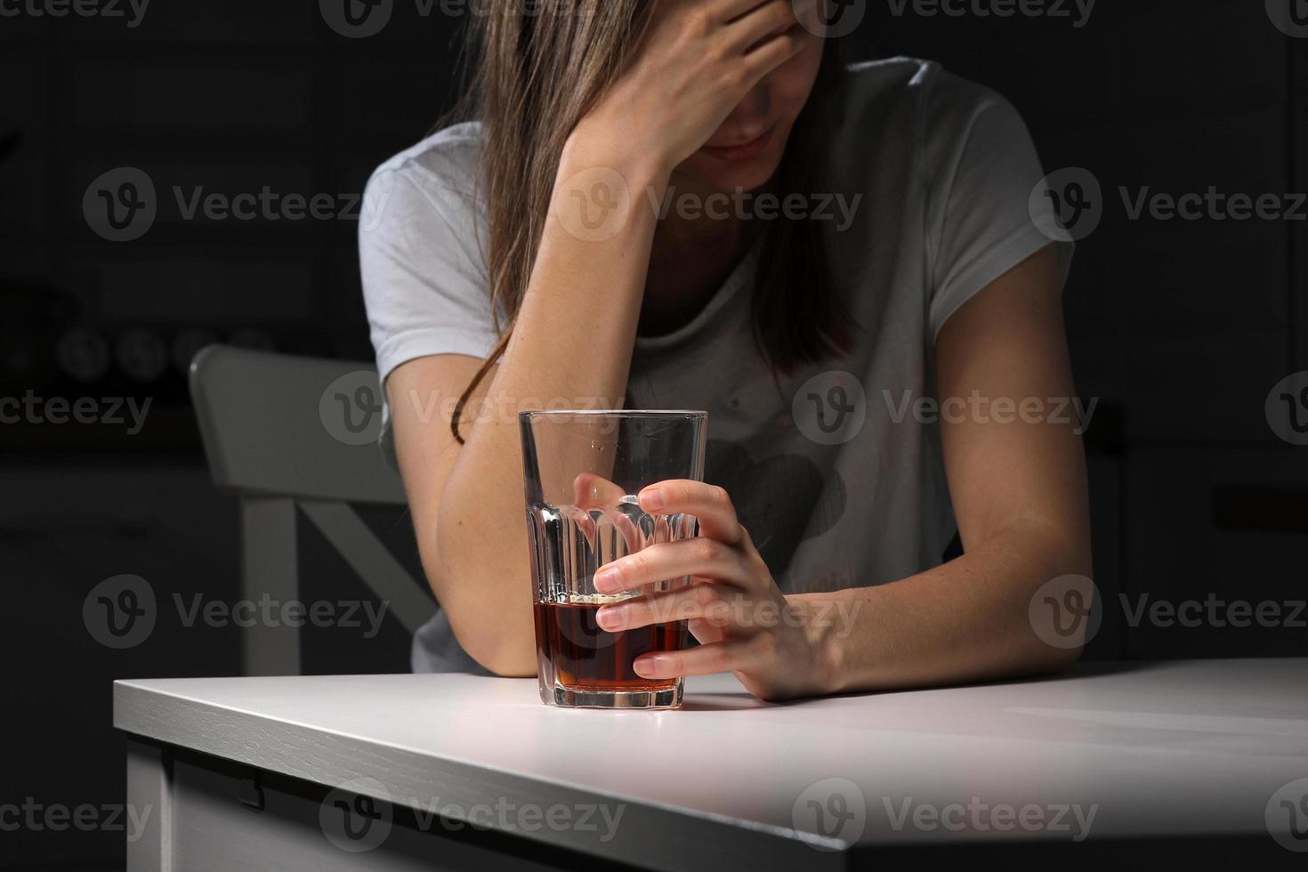 Depressed sad young addicted woman feeling bad drinking whiskey alone at home, stressed frustrated lonely female drinker alcoholic suffer from alcohol addiction having problem, alcoholism concept. photo