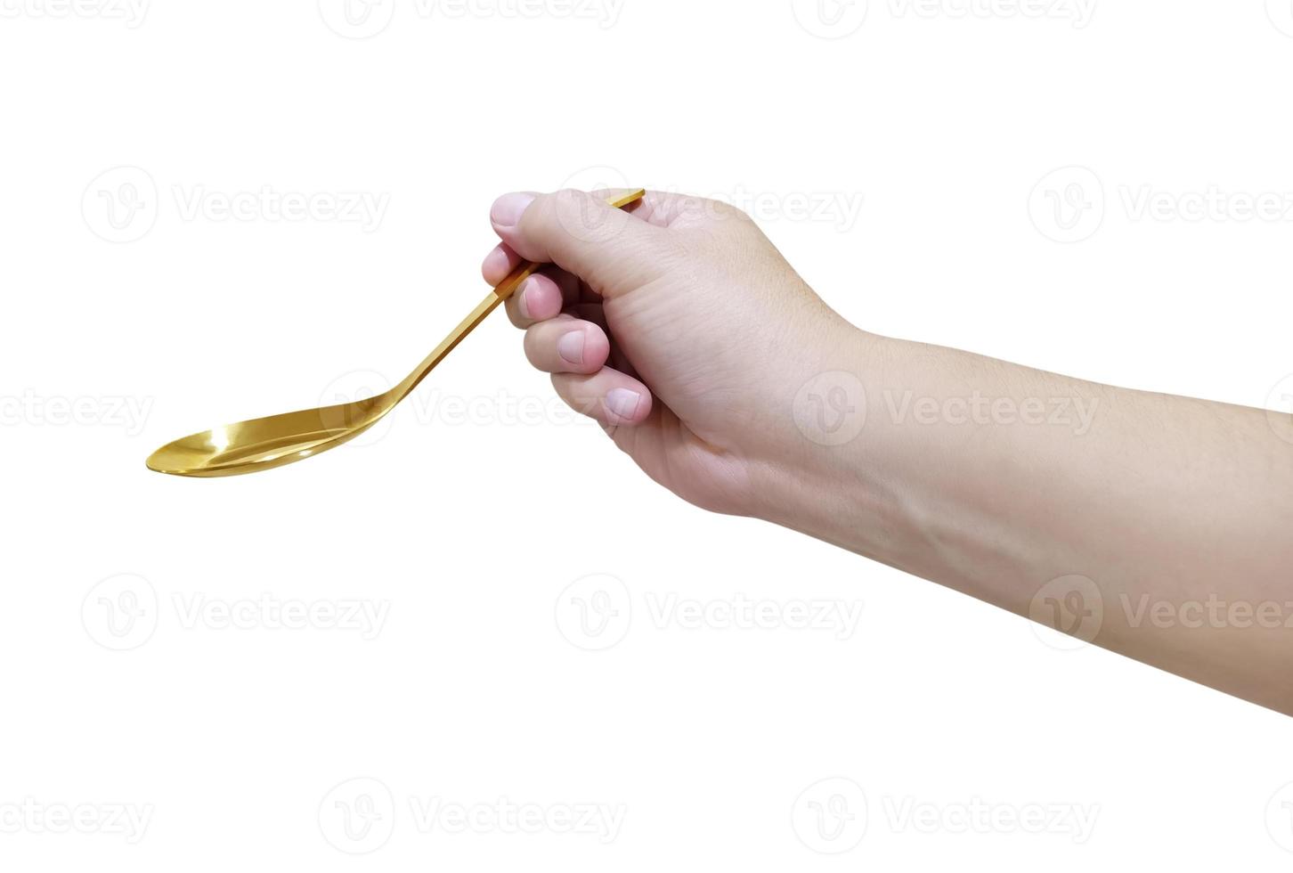 Hand holding Gold plated golden spoon isolated on white background photo