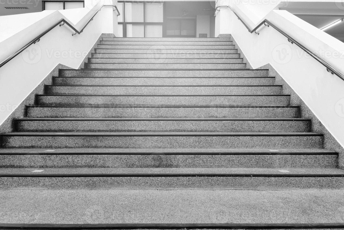 The cement stairs on the way up and down the building have steel handles on the left and right sides to prevent people from falling accidents photo