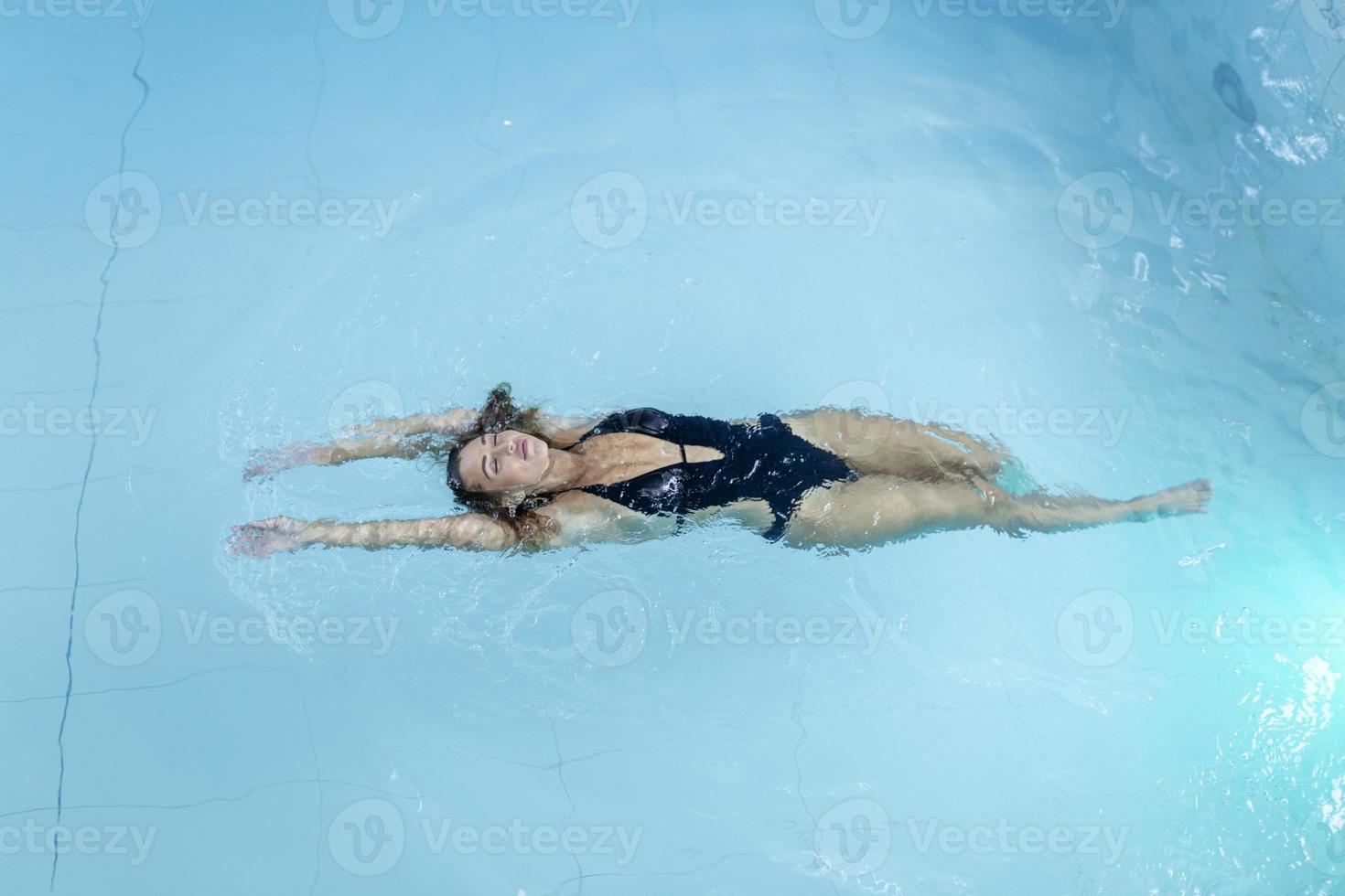 hermosa mujer feliz con cuerpo en forma sexy relajante, flotando en la piscina en el hotel spa. vacaciones de verano vacaciones. estilo de vida saludable. bienestar, belleza, concepto de salud. recreación foto