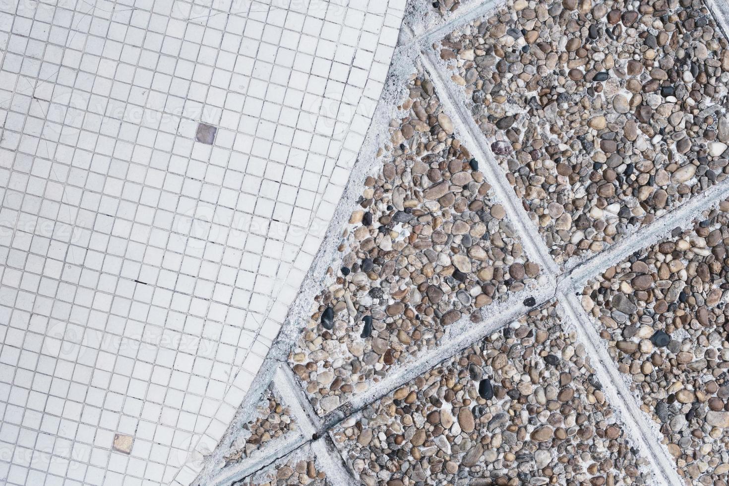 Half of small white and dirty squared ceramic tiles and old brown pebble stone floor texture and pattern, retro mosaic, urban rough textured surface, grunge sidewalk. photo