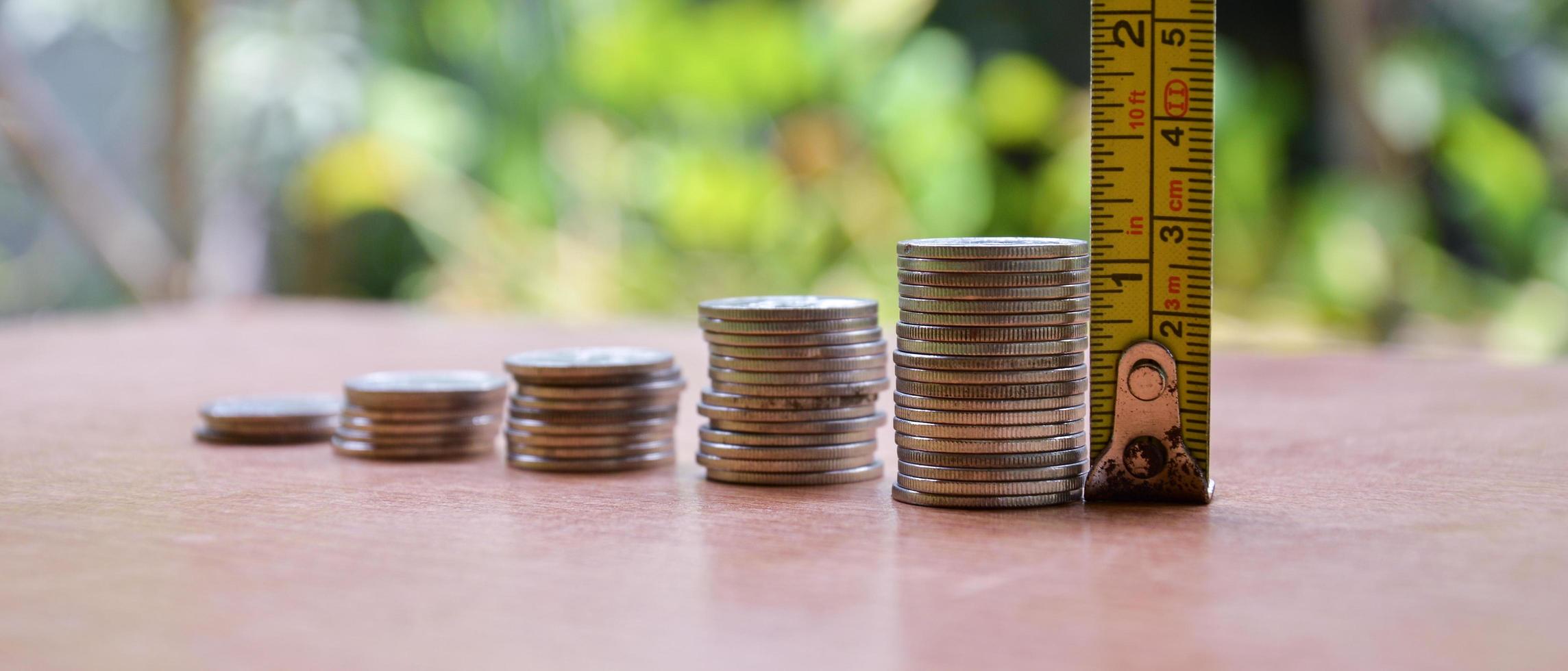 The coins are stacked in a ladder.  Height is measured with yellow tape measure. Finance business growth concept.  VAT  loan interest photo