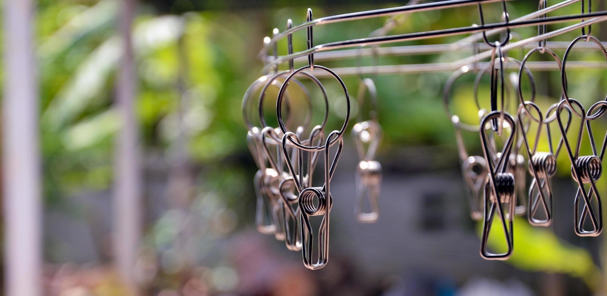 Stainless steel clothes clip, empty, blurred background, during daytime, washing concept. photo