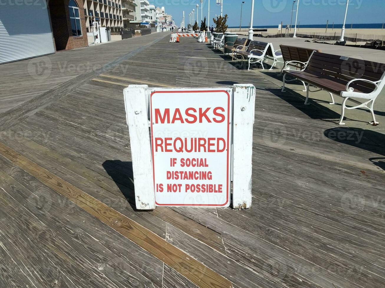 masks required if social distancing is not possible sign on boardwalk photo