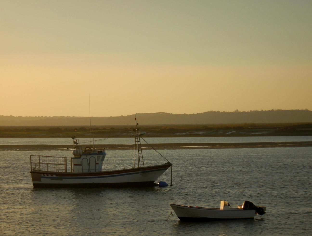 Boats on the shore at sunset photo