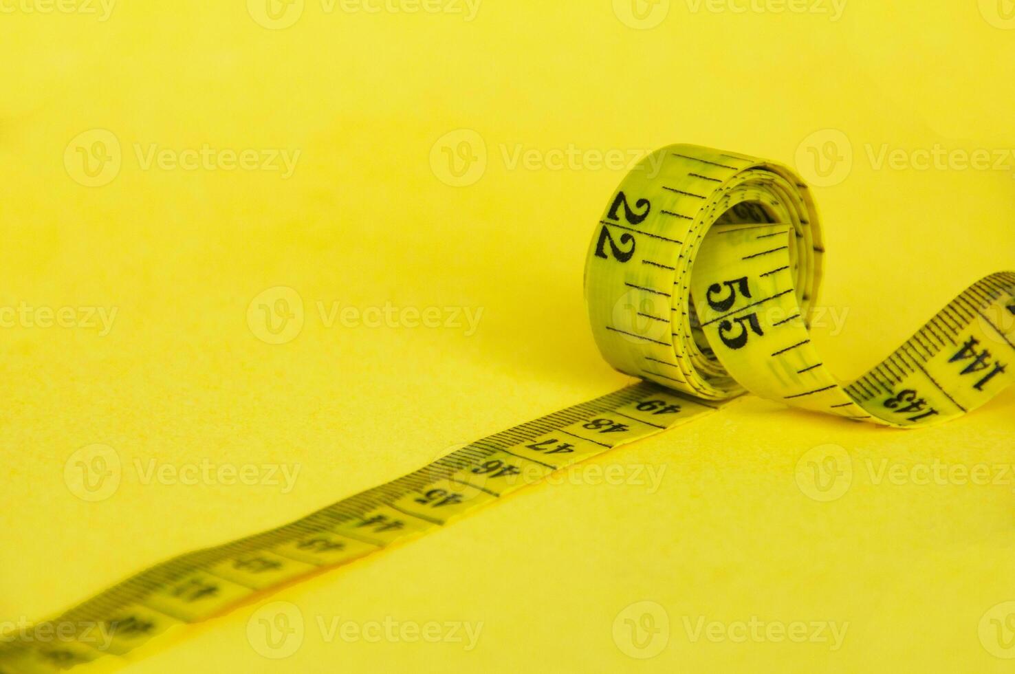 Yellow measuring tape with customizable space for text or ideas. Copy space and weight loss concept photo