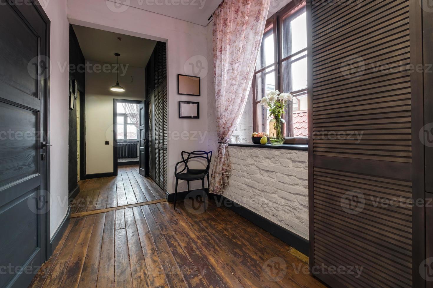long corridor in interior of entrance hall of modern apartments with doors in loft interior photo