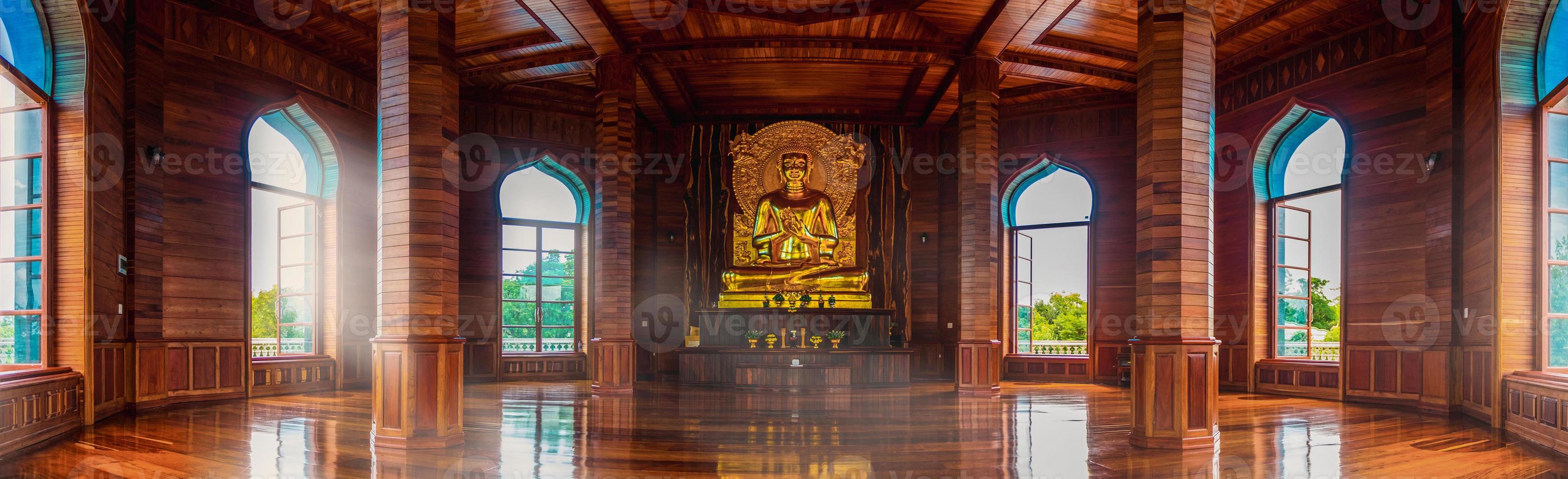 Teak hall and golden Buddha statues inside the temple chedi illuminated by the windows. Make you feel amazed by the beauty of the pagoda. photo