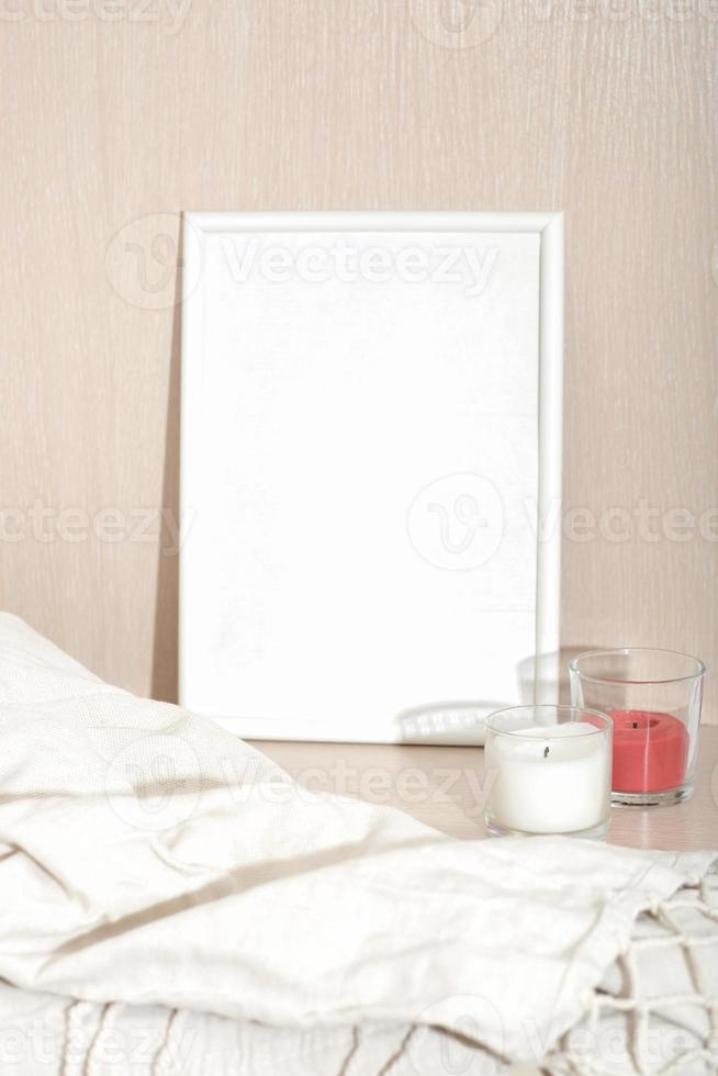 marco blanco vacío para texto, velas de cera de soja blanca y roja y tela escocesa. diseño de casas econaturales. Velas aromáticas de la casa para la relajación y el descanso. foto