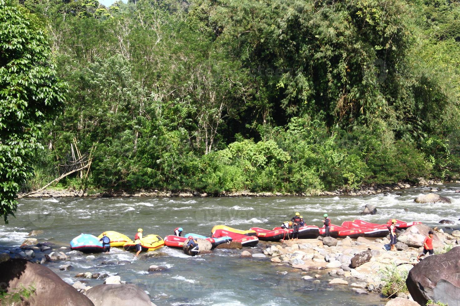 Photo of rafting activities carried out by a group of people on a rocky river with strong currents