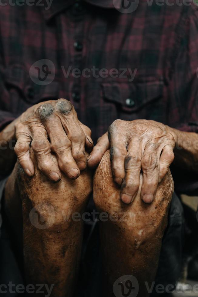 primer plano de las manos arrugadas masculinas, el anciano lleva puesto foto