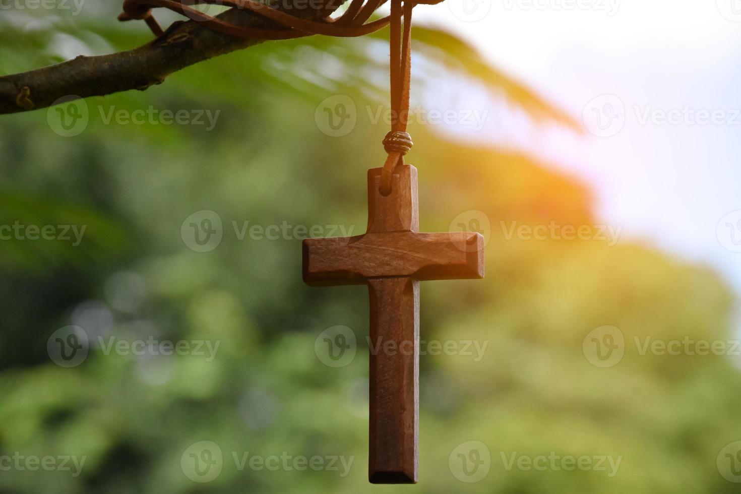 Wooden cross hanging on tree branch, soft and selective focus, natural bokeh tree background, concept for hope, love, forgiveness and belief in Jesus around the world. photo