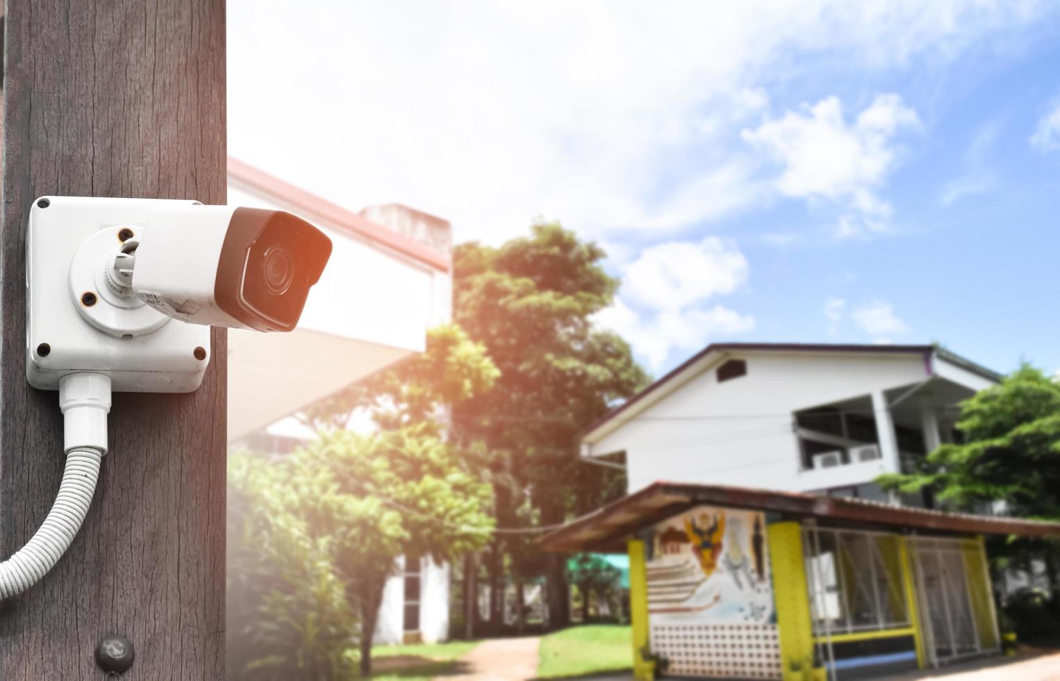 mini ip cctv camera installed on wooden pole to do the security instead of human by monitoring through mobile phone, soft and selective focus. photo