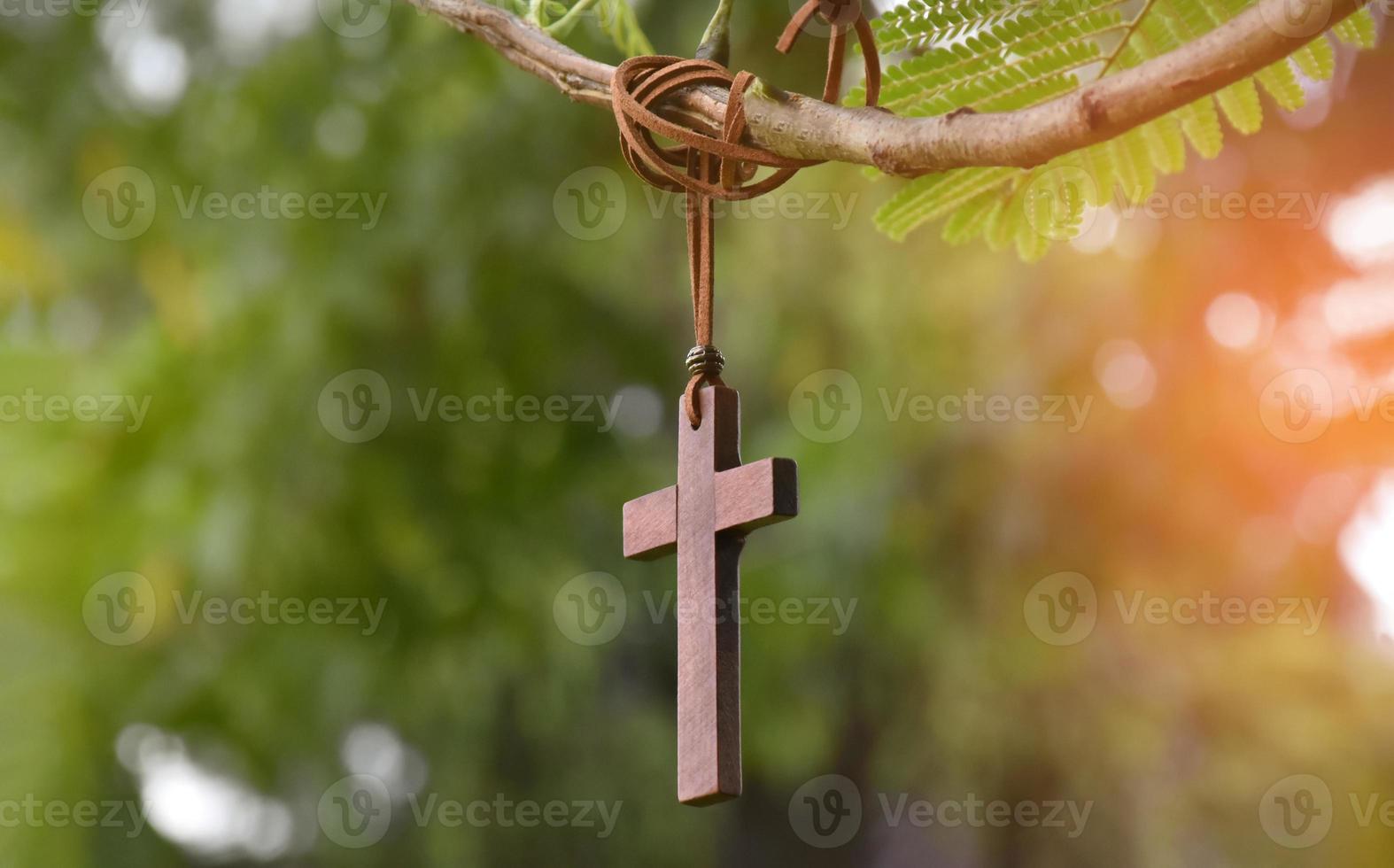 cruz de madera colgada en la rama de un árbol, enfoque suave y selectivo, fondo de árbol natural, concepto de esperanza, amor, perdón y creencia en Jesús en todo el mundo. foto