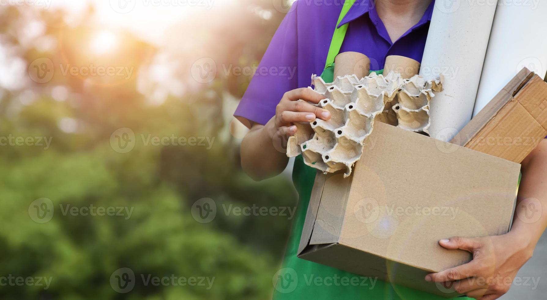 Houseowner is separiting bottles, paper, egg cartons and other stuffs in the black plastic bag in front of the house, concept for reducing global warming, saving our world, soft and selective focus. photo