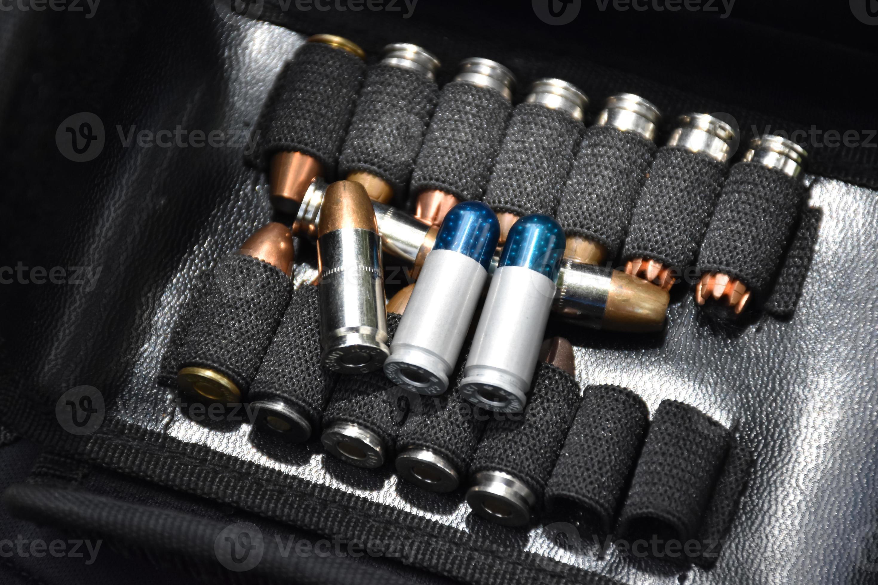 9mm pistol bullets kept in black leather pocket, selective focus on