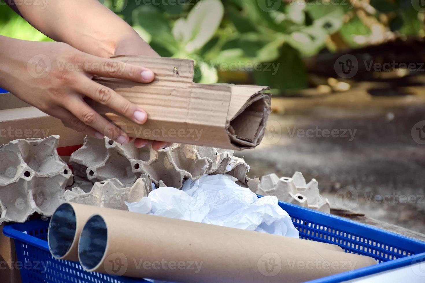 Houseowner is separiting bottles, paper, egg cartons and other stuffs in the black plastic bag in front of the house, concept for reducing global warming, saving our world, soft and selective focus. photo