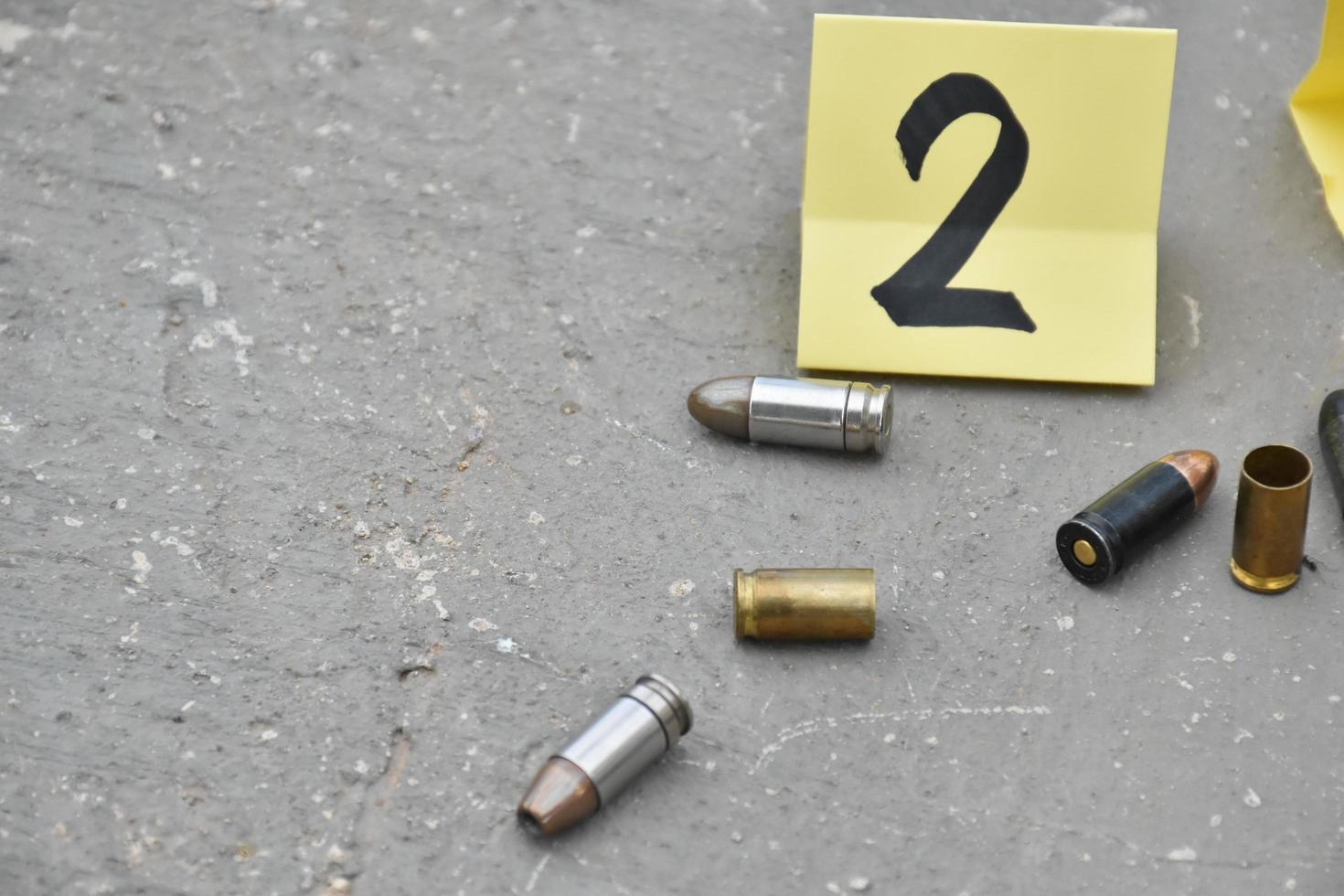 9mm bullet shells holding in fingers and placed near 9mm pistol on black leather background, soft and selective focus on bullet and fingers. photo